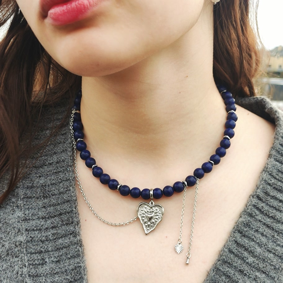 Deep royal blue natural Lapis Lazuli beaded necklace featuring a textured silver heart pendant and delicate dangling silver chain accents.