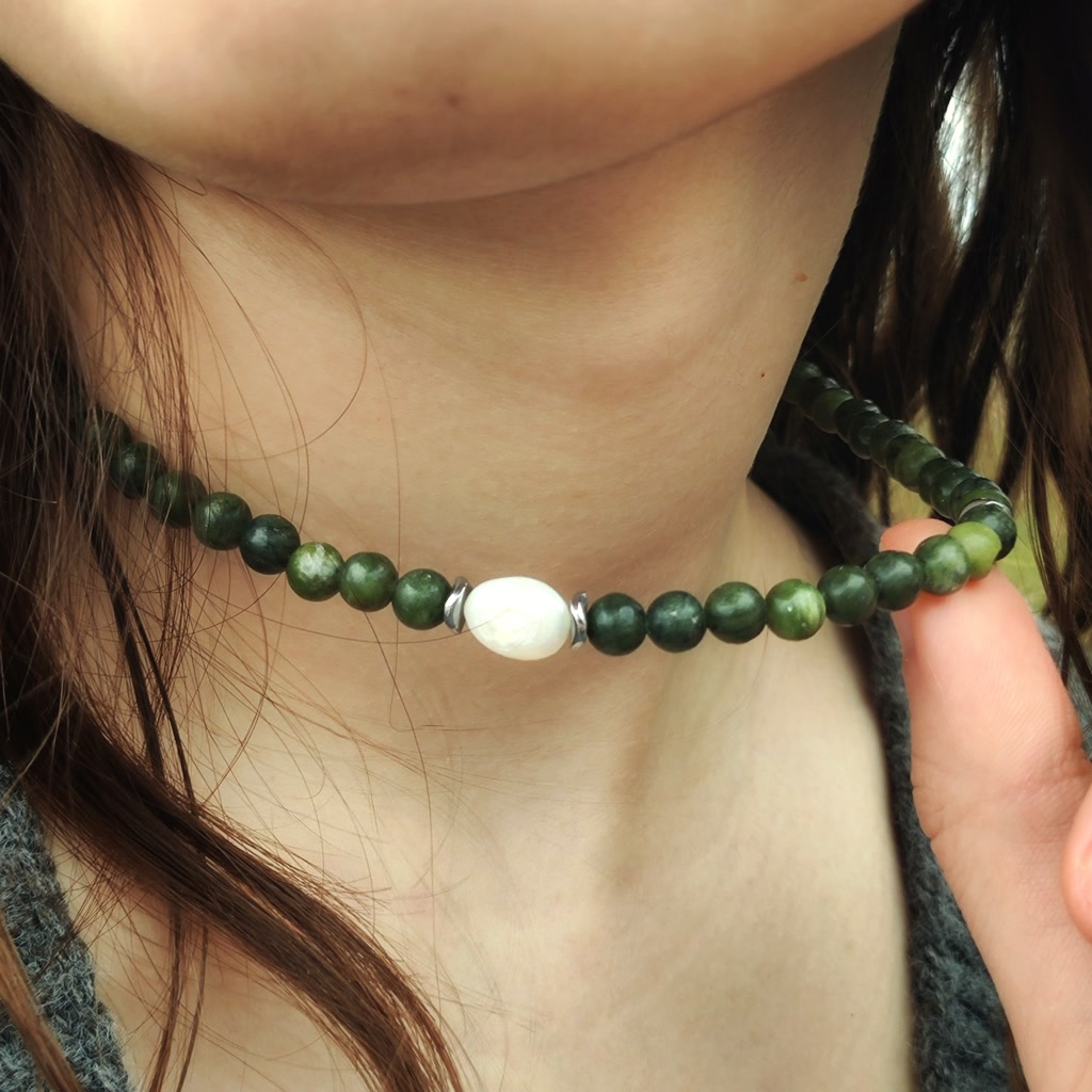 Handmade natural green Jadeite beaded choker necklace featuring a central white Pearl accent and silver spacers on a model's neck.